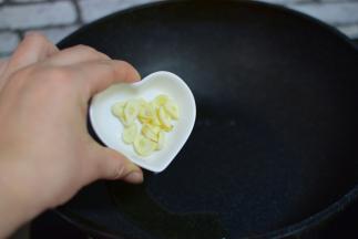 油热，加入蒜片，炒香