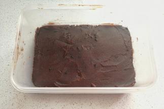 
再取适量豆沙馅放在黑米饭上，然后用刮刀抹平整