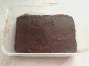 
再取适量豆沙馅放在黑米饭上，然后用刮刀抹平整