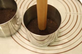 分别倒入两个慕斯圈内，用擀面杖压平压紧，放入冰箱冷藏备用