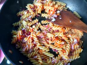 放入洋葱，翻炒，使每一个意面都粘上茄汁。