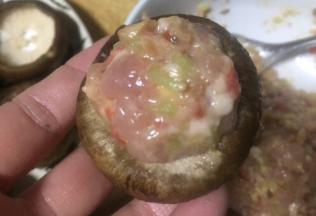 用舀把调好的肉糜舀进香菇里