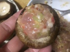 用舀把调好的肉糜舀进香菇里