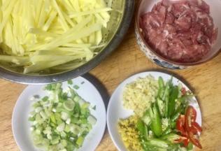 土豆切丝，用清水泡洗至水清澈，沥干备用，大蒜老姜切末双椒切丝