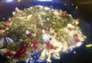 七成热时将蒜姜泡椒泡姜酸菜全部倒入锅内炒