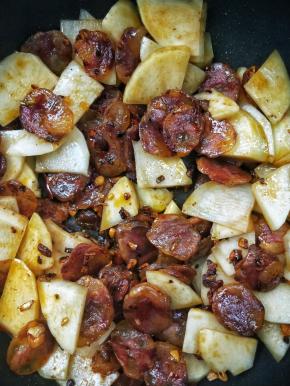 充分将土豆和腊肠翻炒均匀。
～需要翻炒勤快一点，否则土豆容易粘锅。