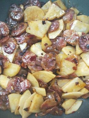 继续勤快翻炒，让土豆完美吸收腊肠的油。