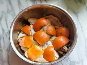 橙子洗干净，将橙子皮片下来，放再鸡翅上面。如图，腌制40分钟。