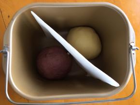 平均分成两份，一份将紫薯粉揉进去，放入面包机中发酵，中间放一张油纸