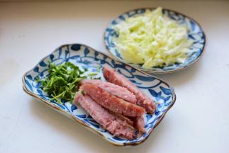 卷心菜洗净切丝、香菜洗净切段、香肠切条；