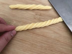 像拧毛巾一样，两手两头拧2圈
又或是一手压住一头，另一手掌轻压面条向一方向搓2下