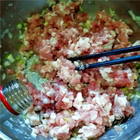 肉馅中放入葱花，倒入油、香油。