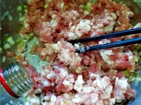 肉馅中放入葱花，倒入油、香油。