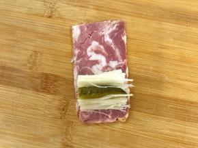 取一培根片放上金针菇中间加上酸黄瓜条。
