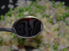 加入青豆，加入酱油，翻炒均匀