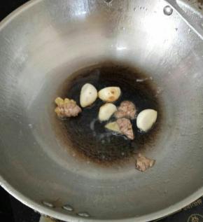 热锅凉油下姜和蒜头，煸至蒜头有点焦黄。