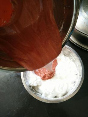 然后再倒回蛋白糊里，继续翻拌至顺滑。把蛋糕糊倒进烤盘里。