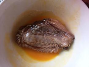 然后将腌制好的鸡翅放入鸡蛋液中翻滚