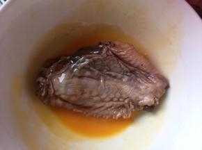 然后将腌制好的鸡翅放入鸡蛋液中翻滚