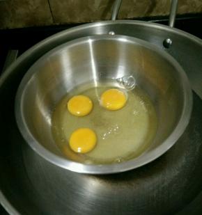 鸡蛋打入盆里，加入白糖和几滴醋，在下面垫上温水。