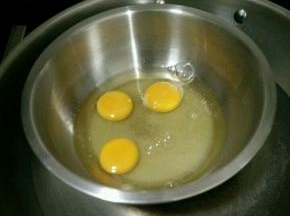 鸡蛋打入盆里，加入白糖和几滴醋，在下面垫上温水。