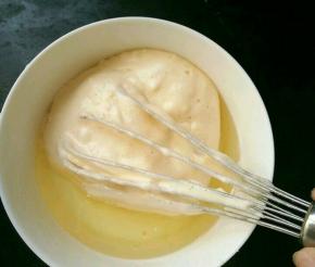 取适量蛋糕糊，放到牛奶和玉米油的混合物里，翻拌均匀。