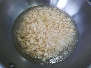 锅中倒油，五成热，倒入花生米。