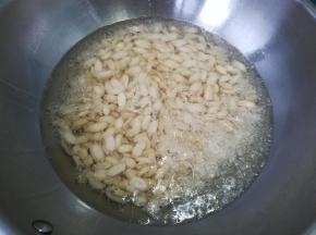 锅中倒油，五成热，倒入花生米。