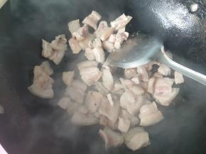 倒入五花肉，煸炒出油，盛出备用。