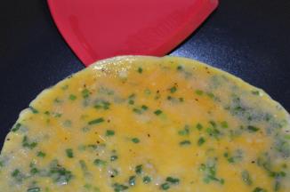 煎至底部变色，上面开始凝结时用铲子在边上轻轻铲开