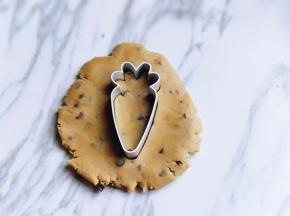 取一小块面团，用手心压扁，再用模具压出形状，如图。