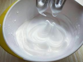 电动打蛋器高速打发，打至湿性发泡时加入最后的三分之一糖粉，，继续打发至蛋白出现细腻的纹路，将电动打蛋器调低速打发一会儿，感觉有些阻力时，就可以停止打发，以免消泡，提起打蛋器有微微的弯勾就可以，如图
