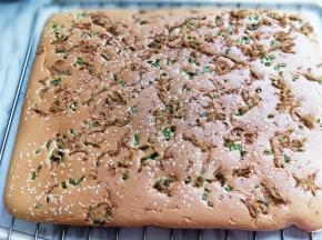 蛋糕烤好后，戴上隔热手套迅速取出烤盘，垂直摔一下，震出热气，趁热撕下油纸，翻面朝上，撕掉油纸后马上将蛋糕翻面，正面朝上，不然水蒸气加热气会导致蛋糕皮被粘掉。