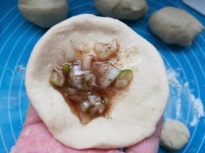 将面团按扁，包入一点儿油酥。