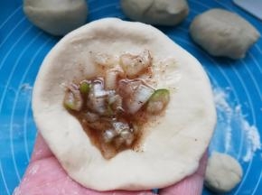 将面团按扁，包入一点儿油酥。