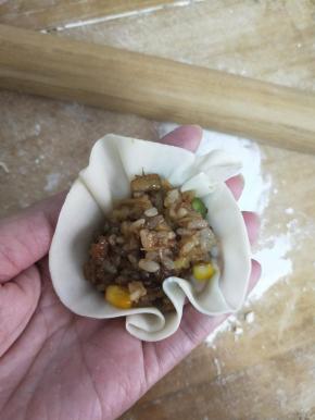 包入一大勺糯米腊肉干贝虾仁馅。