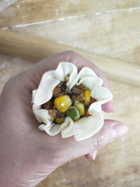 用左手虎口收起来，右手大拇指把馅往中间挤一下，虎口继续收紧，掐出腰身哈哈( •̀∀•́ )