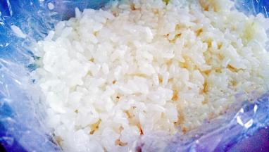 保鲜盒铺好保鲜膜放入一层糯米