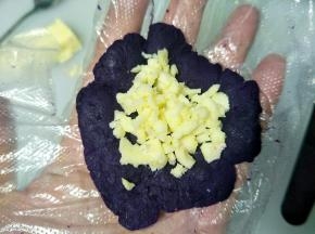 把紫薯弄团按扁，放入适量的芝士碎