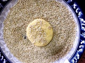 搓成圆形再按成饼状，粘上白芝麻