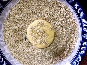 搓成圆形再按成饼状，粘上白芝麻