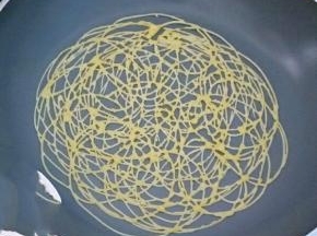 以转圈的方式挤入不粘锅中