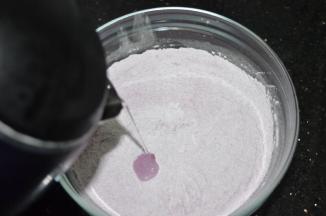 往紫薯糯米粉里加入开水，一边加一边搅拌