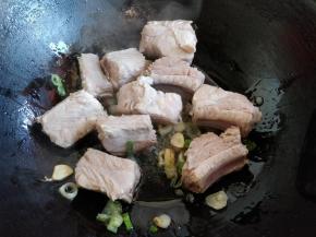 倒入排骨，中火翻炒。把排骨中的水分煸炒出一些，一会儿更容易入味。