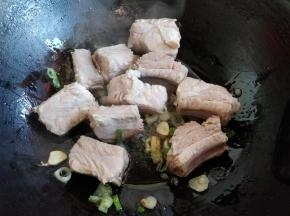 倒入排骨，中火翻炒。把排骨中的水分煸炒出一些，一会儿更容易入味。