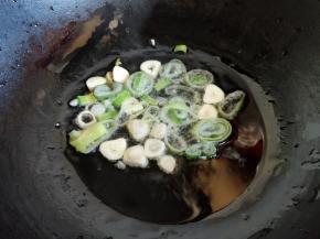 锅中倒植物油，烧热后放入葱蒜，爆香出香味。一般爆锅要用葱白，正好我用的这段葱没葱白了，就直接用葱叶了，味道影响不大，注意下不要糊锅就可以了。