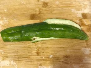 黄瓜去根，用刀平面处用力一拍，黄瓜拍扁裂开。
