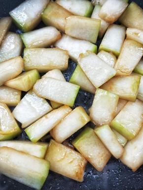 继续翻炒，此时此刻的冬瓜块表面边缘变得有一点透明状。