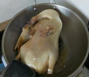 把鸭子放进去，小火慢煎。待底部变黄后翻面。