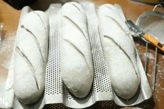 发酵好的面包取出，表面过筛上一层薄薄的面粉，用刀片快速划出割口。